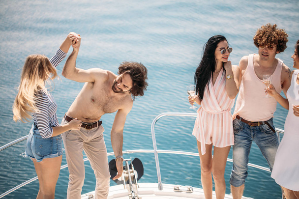 Marine cruise and vacation - youngsters with champagne glasses on boat or yacht - Fotoğraf, Görsel