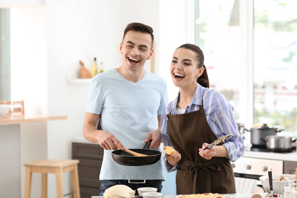 молодая пара готовит вместе на кухне - Фото, изображение