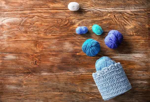 Panier avec boules de fil à tricoter sur table en bois
 - Photo, image