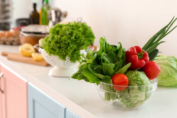 Cuenco con verduras frescas en la mesa en la cocina
 - Foto, imagen