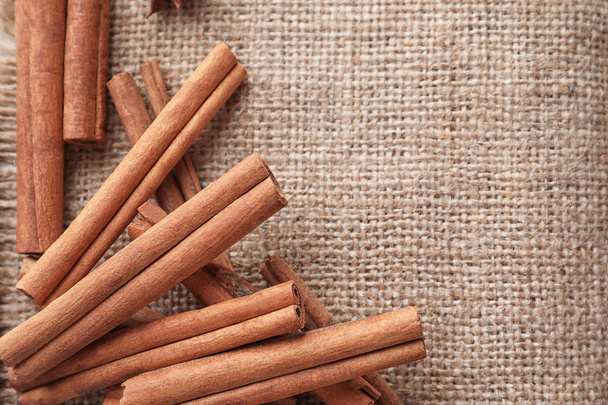 Aromatic cinnamon sticks on sackcloth, closeup - Photo, Image