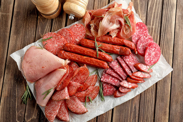 Variedad de deliciosas carnes delicatessen en mesa de madera
 - Foto, imagen