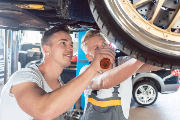 Two dedicated auto mechanics tuning a car - Photo, Image