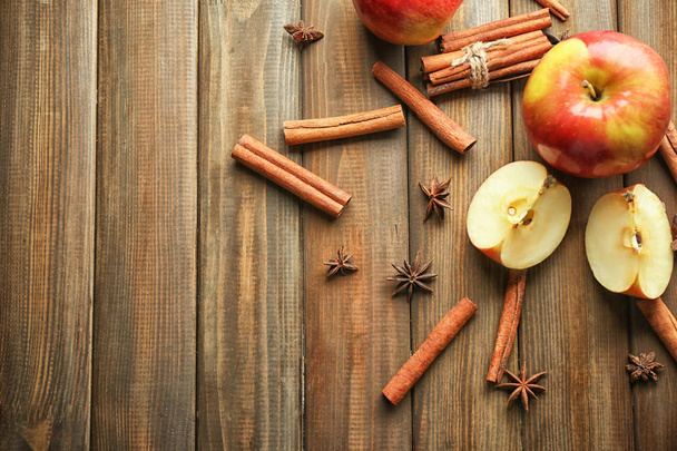 Composition with fresh apples and cinnamon on wooden background - Fotografie, Obrázek