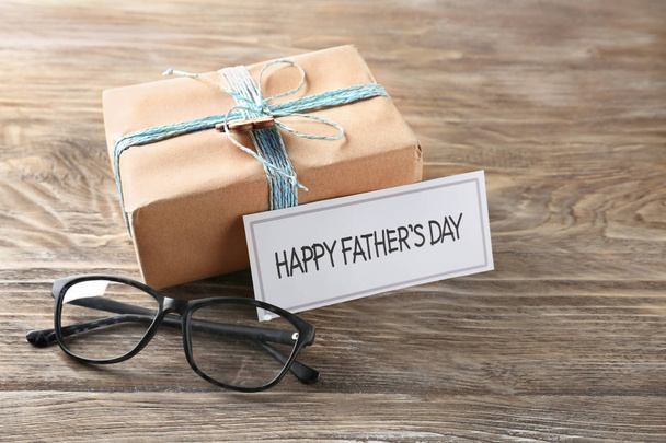 Confezione regalo con bicchieri e biglietto "Happy Father's Day" sul tavolo di legno
 - Foto, immagini