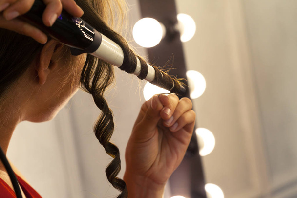 Hairstylist curling hair client in hairdressing salon - Foto, Bild