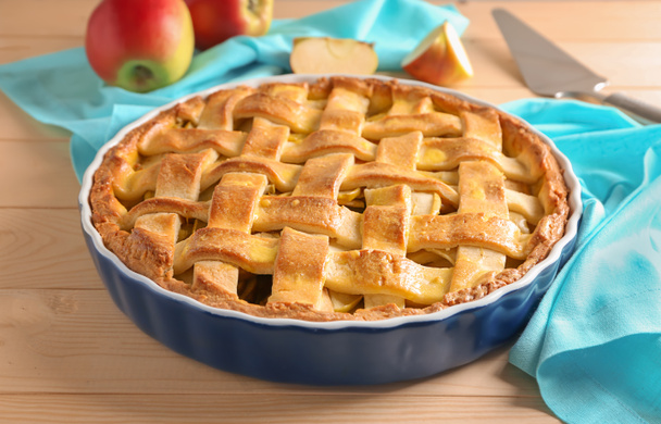 Блюдо с вкусным яблочным пирогом на деревянном столе
 - Фото, изображение