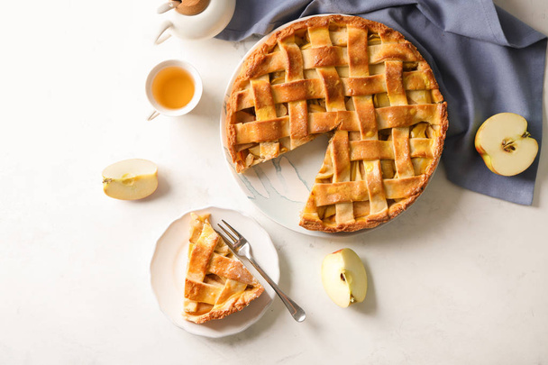 Composition avec délicieuse tarte aux pommes sur fond clair
 - Photo, image