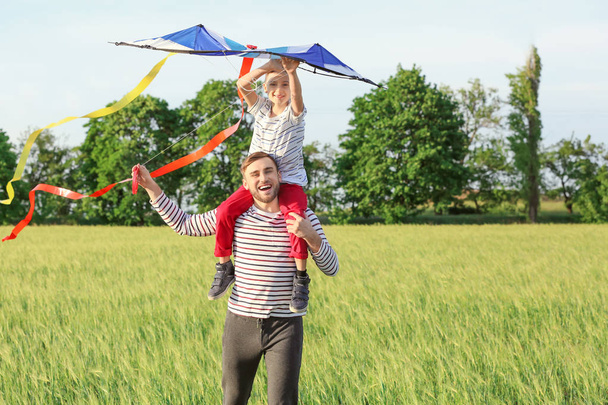 Щасливий батько і син летять повітряний змій в полі
 - Фото, зображення