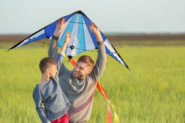 Mutlu baba ve oğul alanında uçurtma uçan - Fotoğraf, Görsel