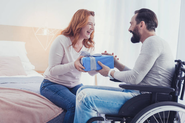 Emotional woman laughing while giving a present to her disabled brother - Φωτογραφία, εικόνα