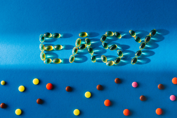 vista superior de letras fácil por pastillas cerca de varias tabletas sobre fondo azul con luz solar
  - Foto, imagen