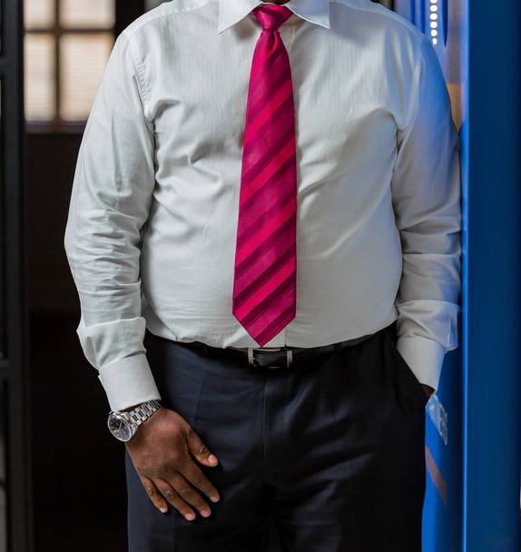 Γκρο πλαν περικοπεί Αφρικανική μαύρο χέρια και αγκαλιά του επιχειρηματία σε ένα κοστούμι με το χέρι στην τσέπη - Φωτογραφία, εικόνα