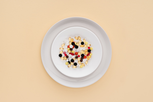 top view of plate with various pills on beige background - Foto, immagini