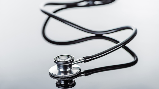 selective focus of stethoscope on glass surface  - Foto, Imagen