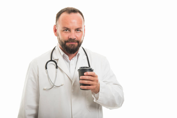 Portrait of male doctor holding to go coffee cup isolated on white background with copyspace advertising area - Foto, imagen