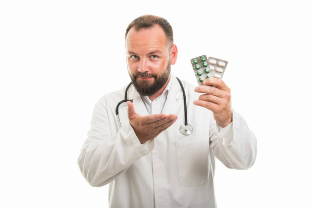 Portrait de médecin masculin montrant blister de pilules isolées sur fond blanc avec espace publicitaire copyspace
 - Photo, image