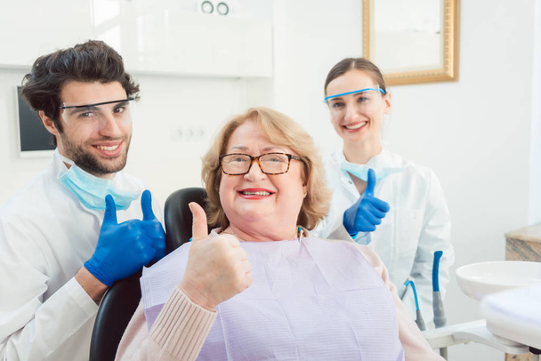 Dentistas e paciente em cirurgia sendo animado
 - Foto, Imagem