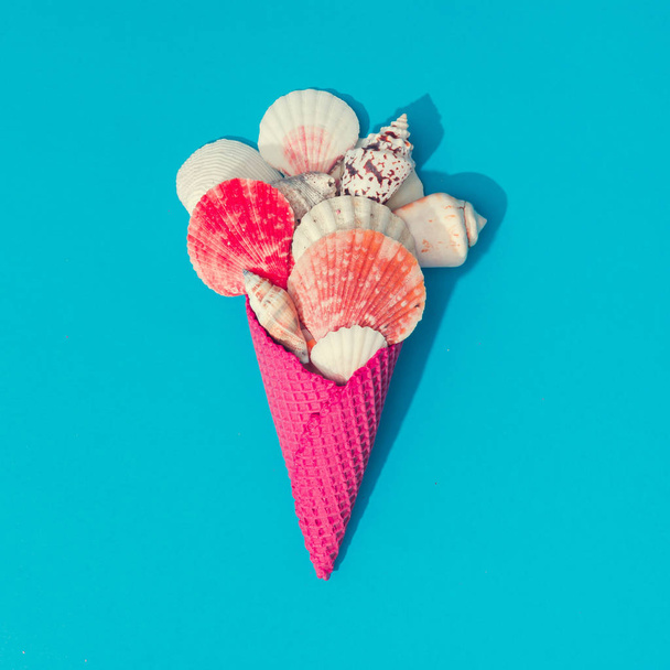 Δημιουργικό καλοκαίρι διάταξη με κοχύλια και παγωτό χωνάκι σε φωτεινό μπλε φόντο, παραλία ελάχιστη έννοια των τροφίμων  - Φωτογραφία, εικόνα