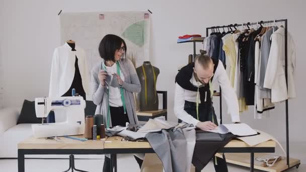 Couturier. Dance and fun work of two designers of clothes in a creative studio for tailoring. Fashion clothing designer man and woman is working with cloth measurements in atelier on . Good work - Πλάνα, βίντεο