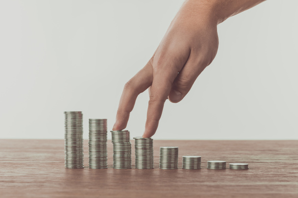 cropped image of man walking with fingers on stacks of coins on table, saving concept - Photo, Image