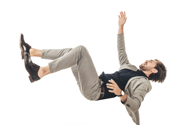 asustado joven hombre de negocios en traje cayendo aislado en blanco
 - Foto, Imagen