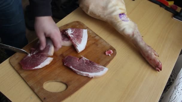 Man holding knife with hands, cutting, chopping, preparing pig  raw, fresh meat steak for barbecue. Close up video footage of butcher cutting raw red bbq meat on cutting board. - Footage, Video
