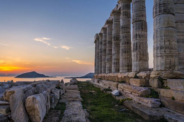 Sounion, Attica / Grecia: Colorato tramonto a Cape Sounion e le rovine del tempio di Poseidone con l'isola Patroklos visibile sullo sfondo
. - Foto, immagini