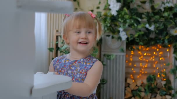 kleines Mädchen spielt mit weißem hölzernen Schaukelpferd - Filmmaterial, Video