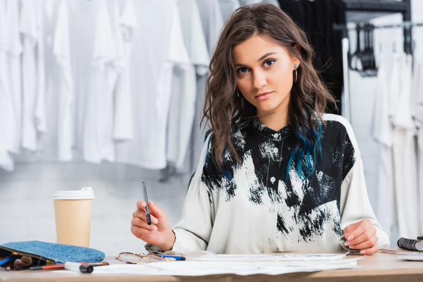 kobiece projektant mody pracy przy stole z filiżanki kawy w pracowni projektowania odzieży - Zdjęcie, obraz