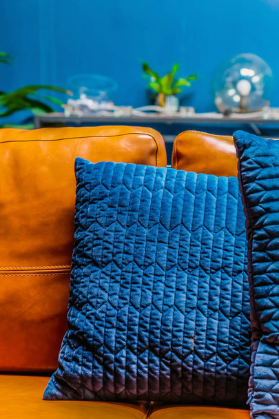 Крупним планом деталі синьої подушки на шкіряному дивані
 - Фото, зображення