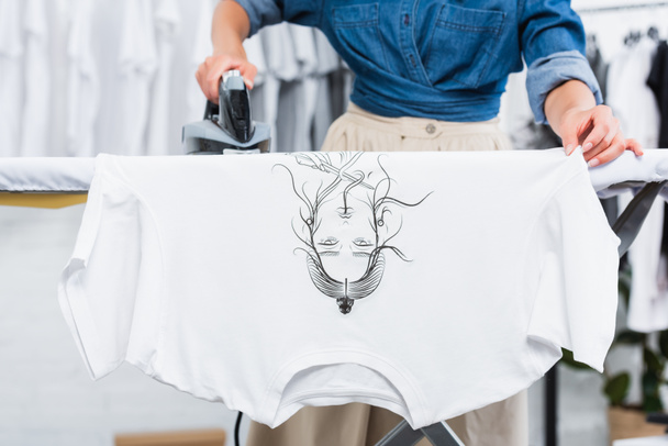 image recadrée de la créatrice t-shirt repassage avec impression dans le studio de conception de vêtements
 - Photo, image