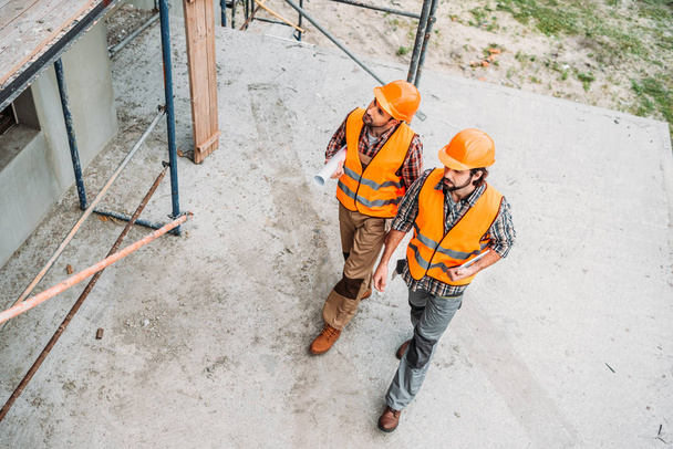 high angle view of builders walking at construction site - Photo, Image