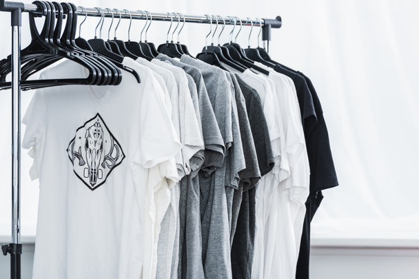 enfoque selectivo de camisetas con estampado en perchas en estudio de diseño de ropa
  - Foto, Imagen