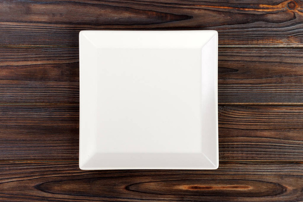 Placa branca quadrada vazia na vista superior de madeira da tabela
. - Foto, Imagem