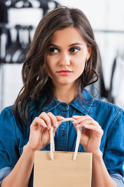 atrakcyjna młoda kobieta holing worek papierowy w pracowni projektowania odzieży - Zdjęcie, obraz