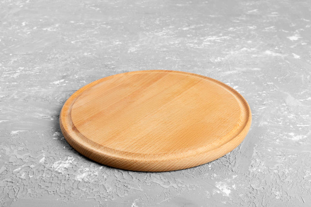 Assiette ronde en bois vide sur table texturée. Assiette en bois pour servir des aliments ou légumes aux clients
. - Photo, image