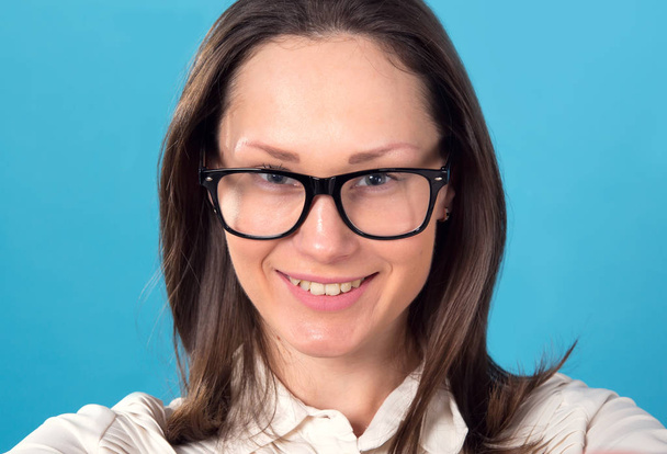 Portrait of business woman. Female face close-up on a blue background. - Foto, Imagen