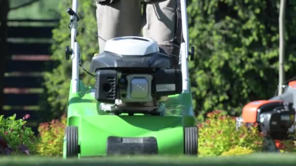 Travailleur de jardin avec machine de tondeuse à essence tondre herbe arrière-cour
. - Séquence, vidéo