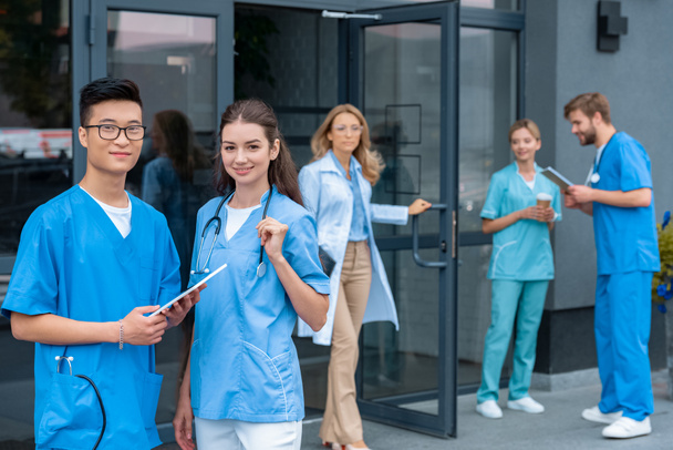 Lehrer öffnet Türen, multikulturelle Studenten stehen auf dem Hof der medizinischen Universität - Foto, Bild