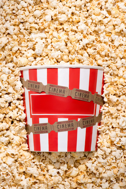 flat lay with disposable bucket, crunchy popcorn and retro cinema tickets - Foto, imagen