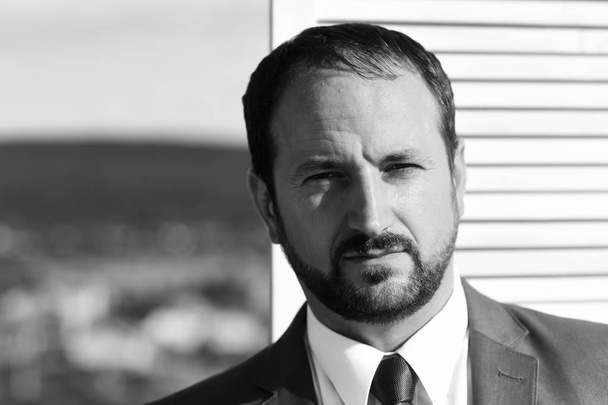 Επιχειρηματίας φοράει έξυπνο κοστούμι και γραβάτα σε ξύλινο τοίχο - Φωτογραφία, εικόνα