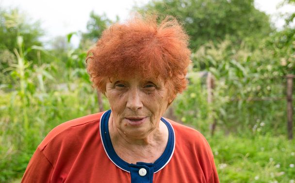 La mujer rusa de 70 años en el jardín veraniego
 - Foto, Imagen