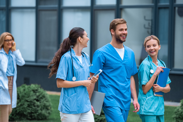 uśmiechający się studentów medycyny i wykładowca spaceru na ulicy, w pobliżu Uniwersytetu - Zdjęcie, obraz