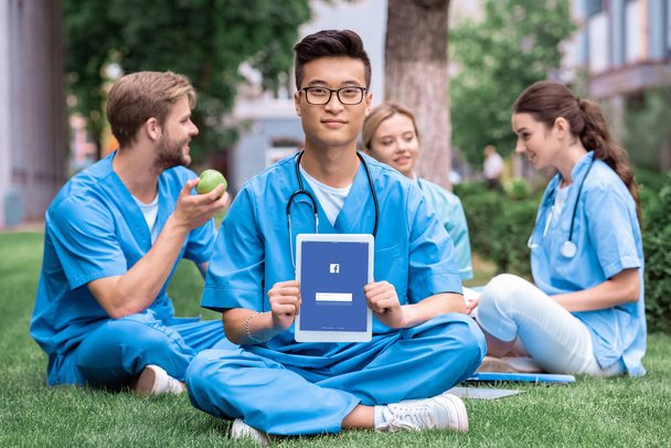 Asian student medycyny gospodarstwa tablet z załadowany na Facebooku - Zdjęcie, obraz