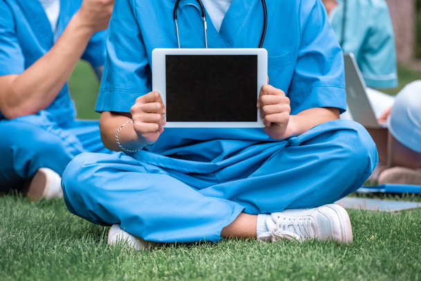 cropped image of medical student holding tablet with blank screen - 写真・画像