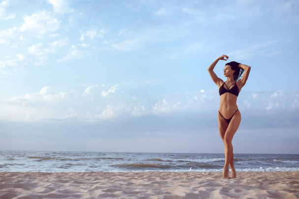 hermosa chica con un físico deportivo en un traje de baño en la playa
. - Foto, imagen