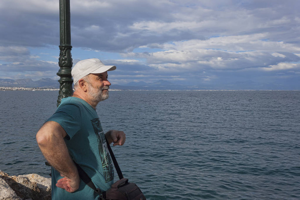 Podobizna muže zralý věk, stojí u moře a při pohledu do dálky. Loutraki, Řecko - Fotografie, Obrázek