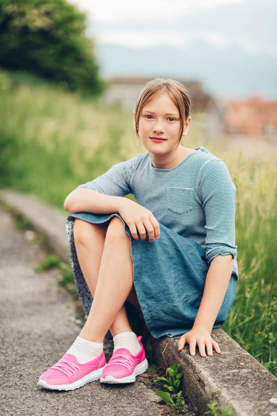 Retrato al aire libre de niña linda preadolescente de 10-11 años, con camiseta de rayas, falda de mezclilla y zapatillas de deporte de color rosa
 - Foto, imagen