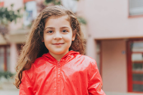 Al aire libre retrato de cerca de adorable niña de 5 años de edad con abrigo de lluvia rojo
 - Foto, Imagen